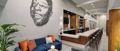 A modern living room with a blue sofa, a round coffee table, and a unique wall art piece.