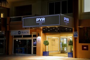 PVR Fuengirola -hotellissa on kyltti, sisäänkäynti ja kaksi ruukussa olevaa kasvia.