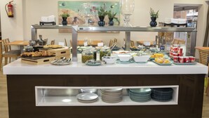 A buffet setup with various food items, utensils, and decorative elements.