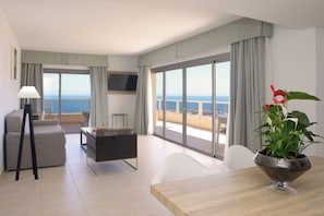 Suite, vista al mar | Área de sala de estar | Televisión de 42 pulgadas con canales vía satélite