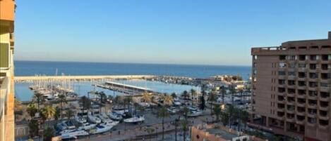 Puerto deportivo con barcos, piscina y vista al mar.