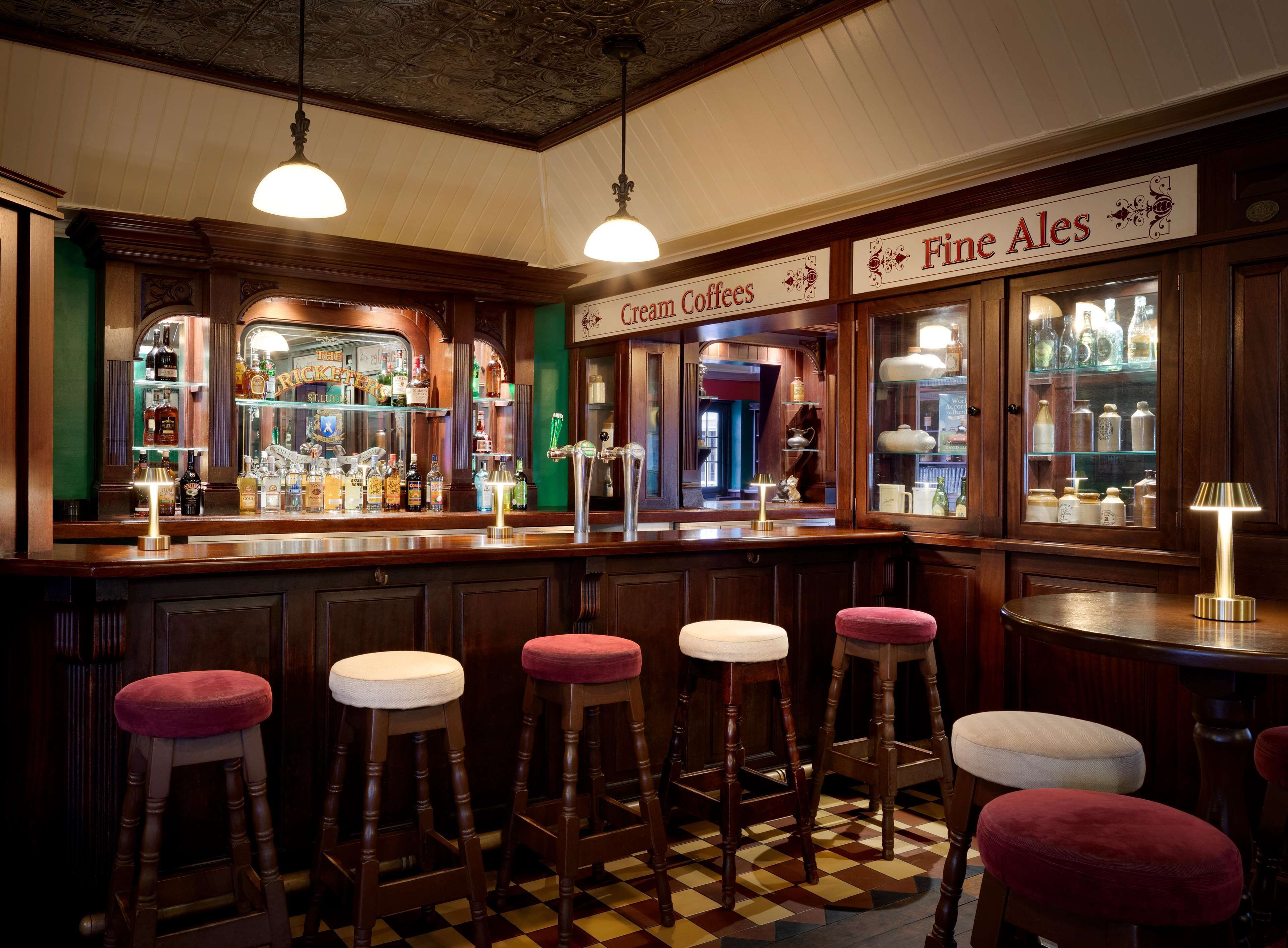 En bar med skrammelstole, en disk med flasker og et skilt med teksten "Fine Ales".