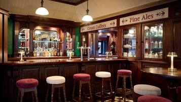 En bar med skrammelstole, en disk med flasker og et skilt med teksten "Fine Ales".