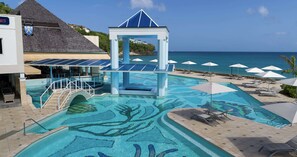 A pool with a blue and white structure, lounge chairs, and umbrellas. - Sandals Regency La Toc - ALL INCLUSIVE Adults Only (Castries)