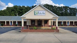 A motel with a 'Relax Inn' sign, a covered front porch, and a brick facade.