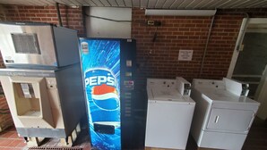 A vending machine with a Pepsi logo, a water dispenser, and a washing machine.