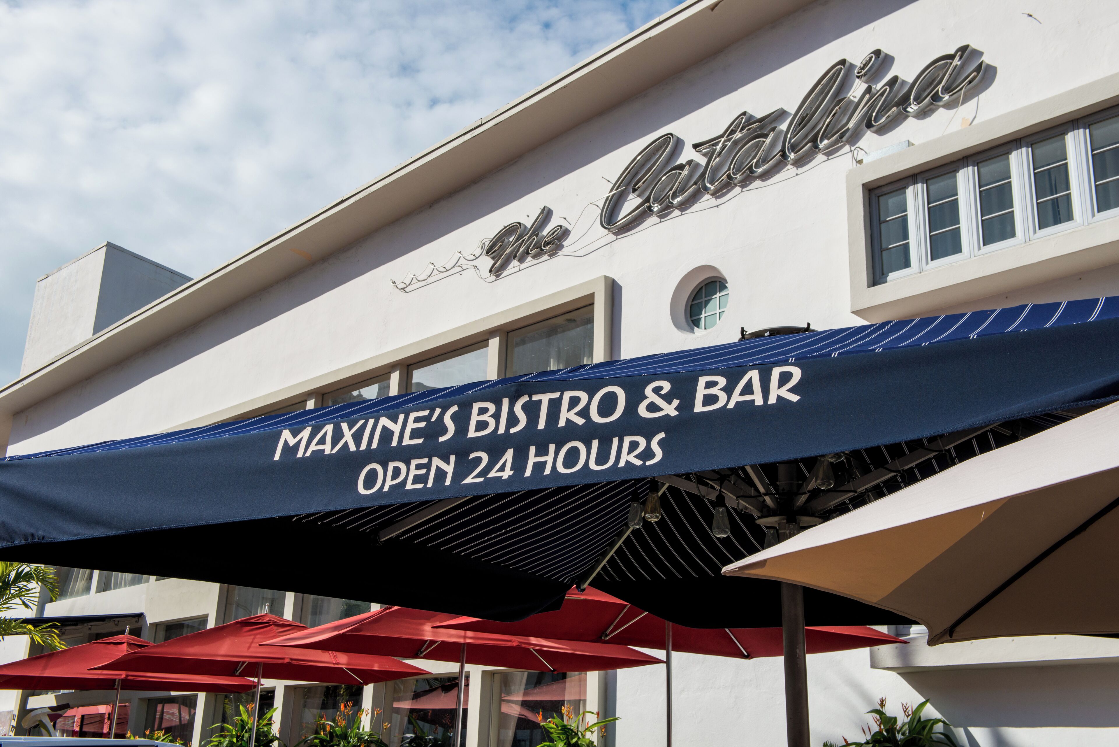 Un bâtiment sur lequel on peut lire l’inscription « Bistro et bar de Maxine » et « Ouvert 24 heures sur 24 ».