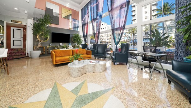 Un hall d’entrée spacieux au design moderne, doté d’un grand téléviseur, de sièges confortables et de grandes fenêtres offrant une vue sur la ville.