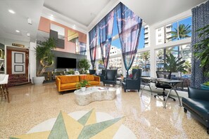 Un hall d’entrée spacieux au design moderne, doté d’un grand téléviseur, de sièges confortables et de grandes fenêtres offrant une vue sur la ville.