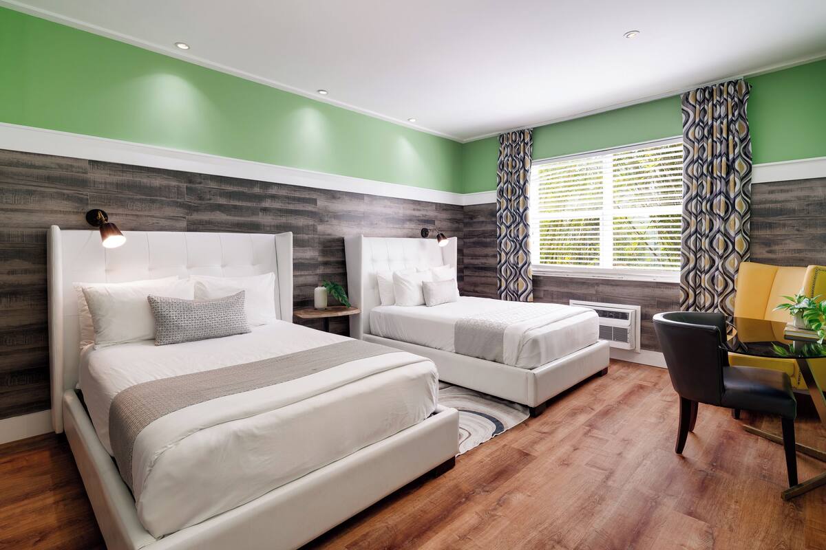 Une chambre avec deux lits, un bureau et une chaise.