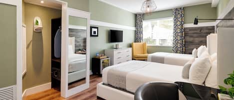 A modern bedroom with a bed, a desk, a chair, a TV, and a wardrobe.