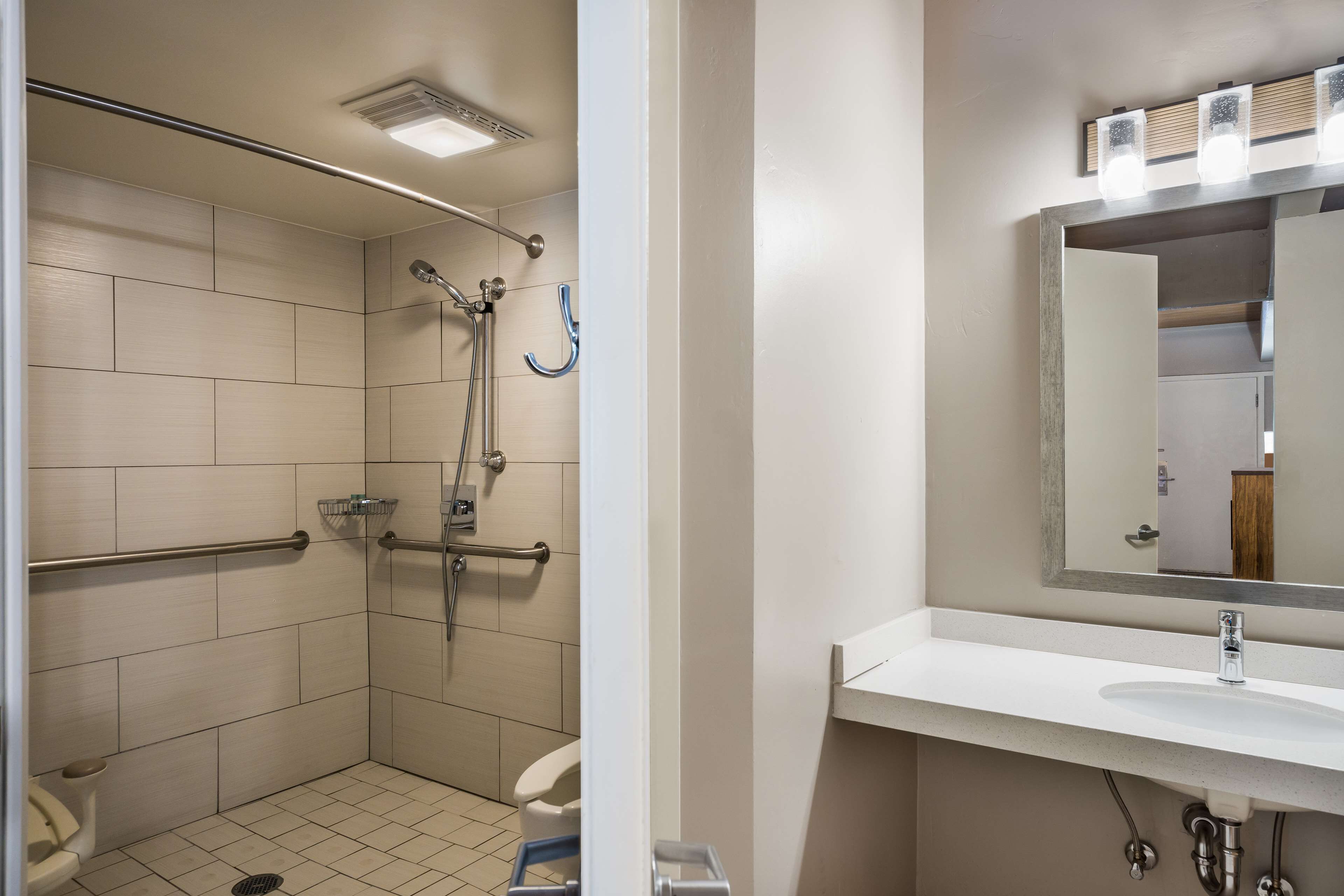 Een moderne badkamer met douche, toilet en wastafel.