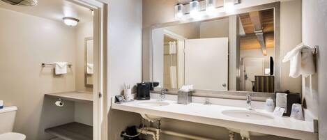 Un baño moderno con lavamanos doble, inodoro y ducha.