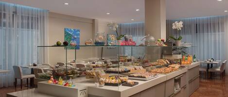 Een buffet met diverse gerechten en een glazen vitrine.