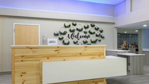 A reception desk with a 'Welcome' sign, a 'Marriott Bonvoy' sign, and a 'Hotel Office' sign.