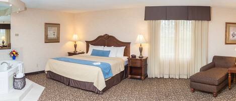 A hotel room with a bed, a desk, a chair, a TV, a lamp, and a bathroom.