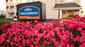 A Howard Johnson Inn sign with a large flower bed in front. - Howard Johnson by Wyndham Salinas (Salinas)