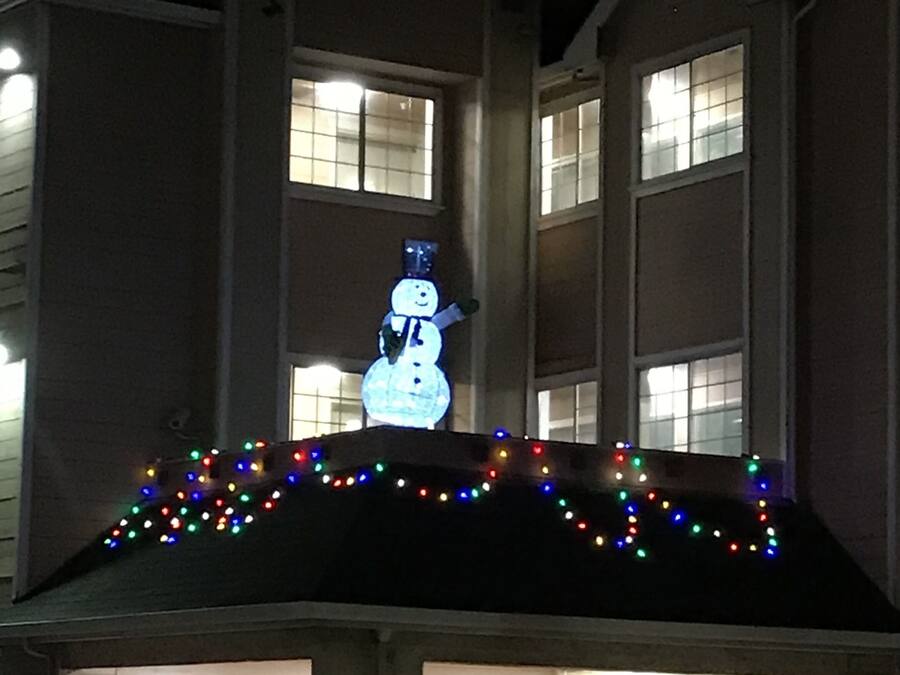 Un edificio decorado con un muñeco de nieve y luces de colores en el techo.
