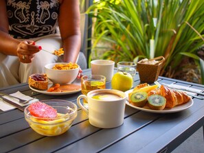 A table with breakfast items including toast, fruit, and a croissant.