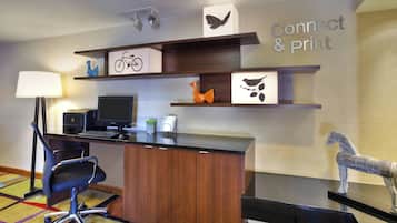 Un espacio de oficina moderno con un escritorio, computadora y silla de oficina. Hay estantes con objetos decorativos y un letrero que dice "Connect & Print".