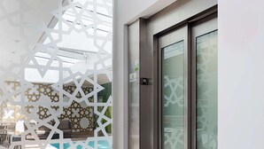 A modern interior with a sliding glass door leading to an outdoor pool area.