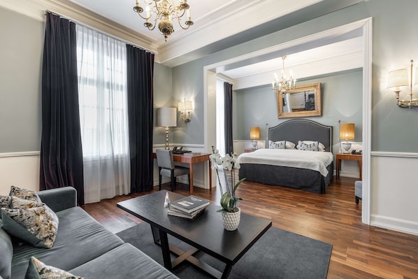 Une chambre d’hôtel moderne équipée d’un canapé, d’une table basse, d’un bureau et d’un lit.