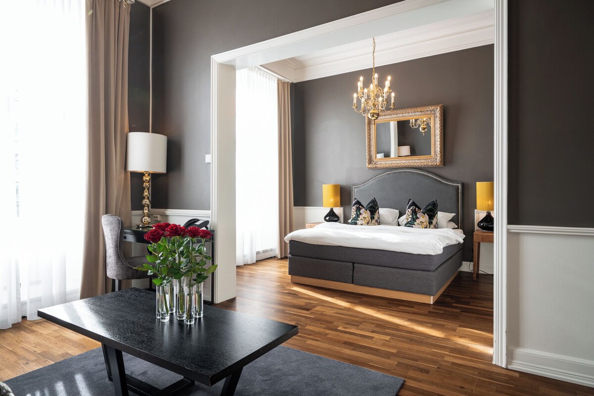 Bedroom with chandelier and luxurious touches everywhere, like a vase of roses