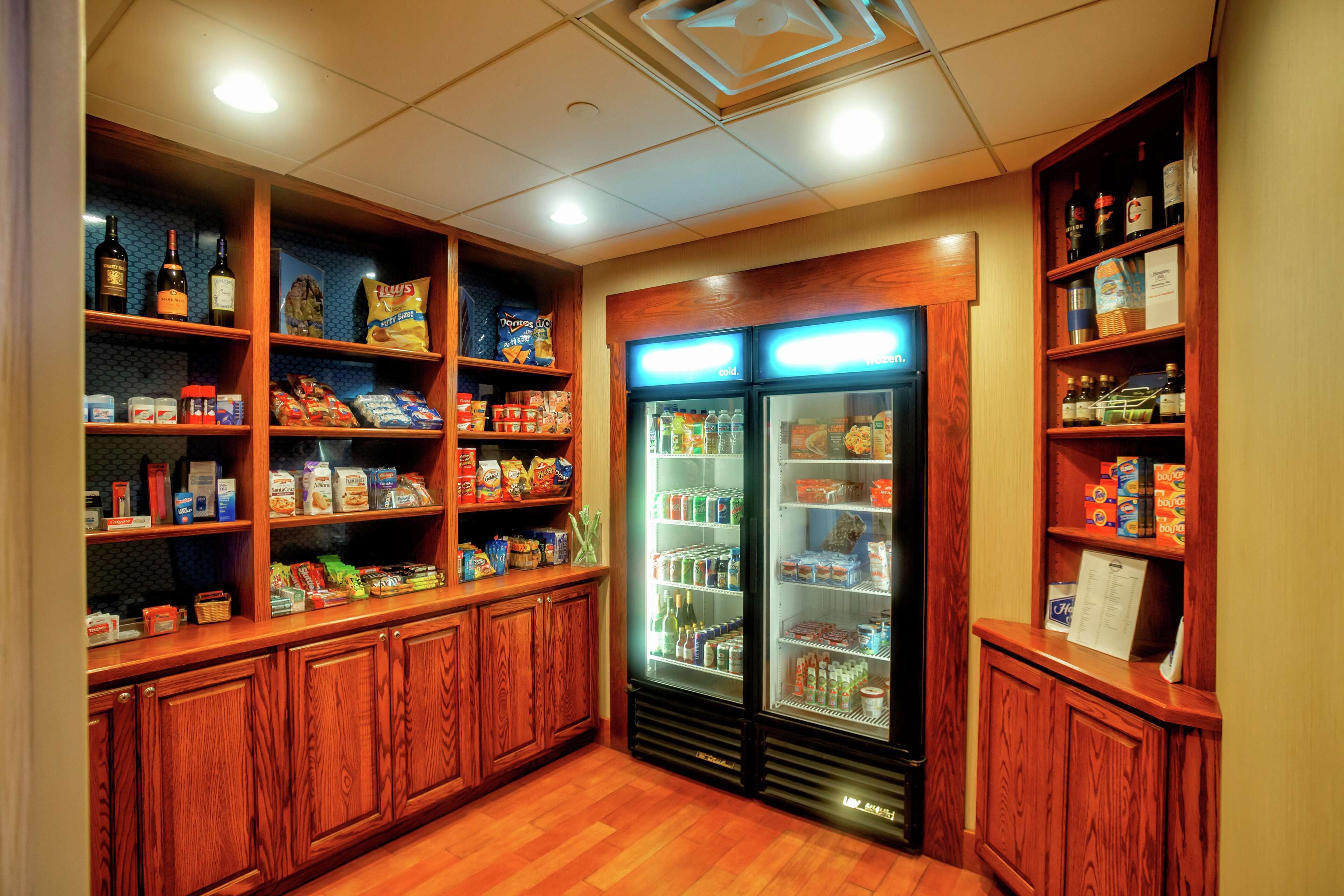 A hotel pantry with shelves stocked with snacks, beverages, and condiments.