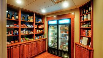 A hotel pantry with shelves stocked with snacks, beverages, and condiments.