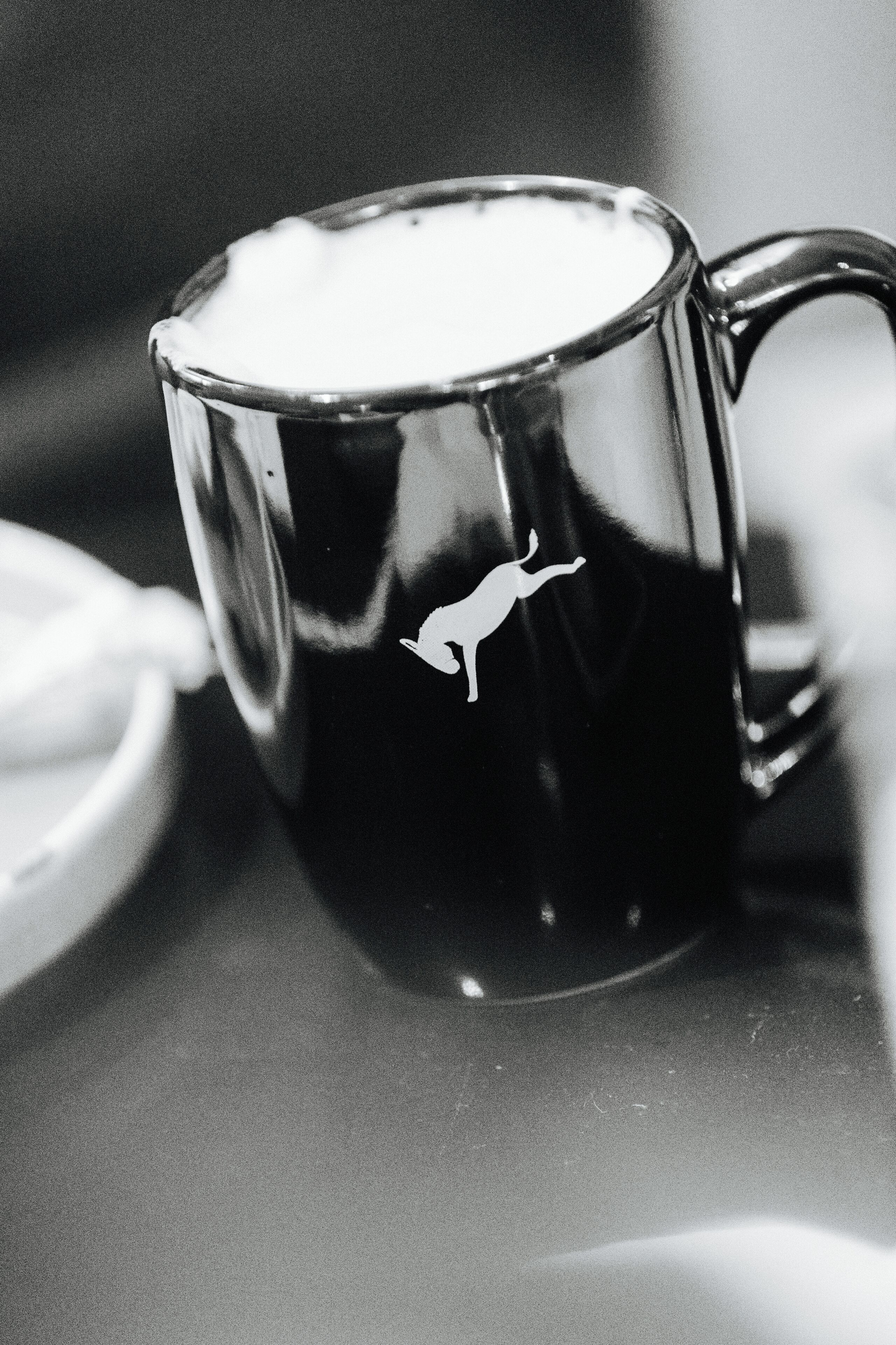 A black mug with a kangaroo logo.