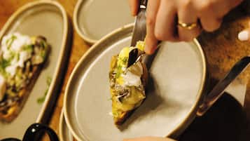 Une personne qui découpe un morceau de nourriture dans une assiette.