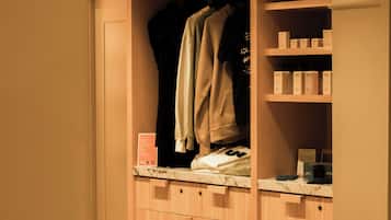 Een houten garderobe met meerdere planken, een kledingroede en een aanrecht met spullen.