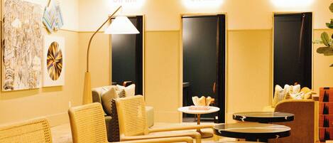 Una hall d'albergo con zone relax, una reception e opere d'arte alle pareti.