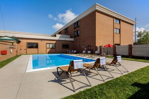 Una piscina al aire libre, sillones reclinables de piscina