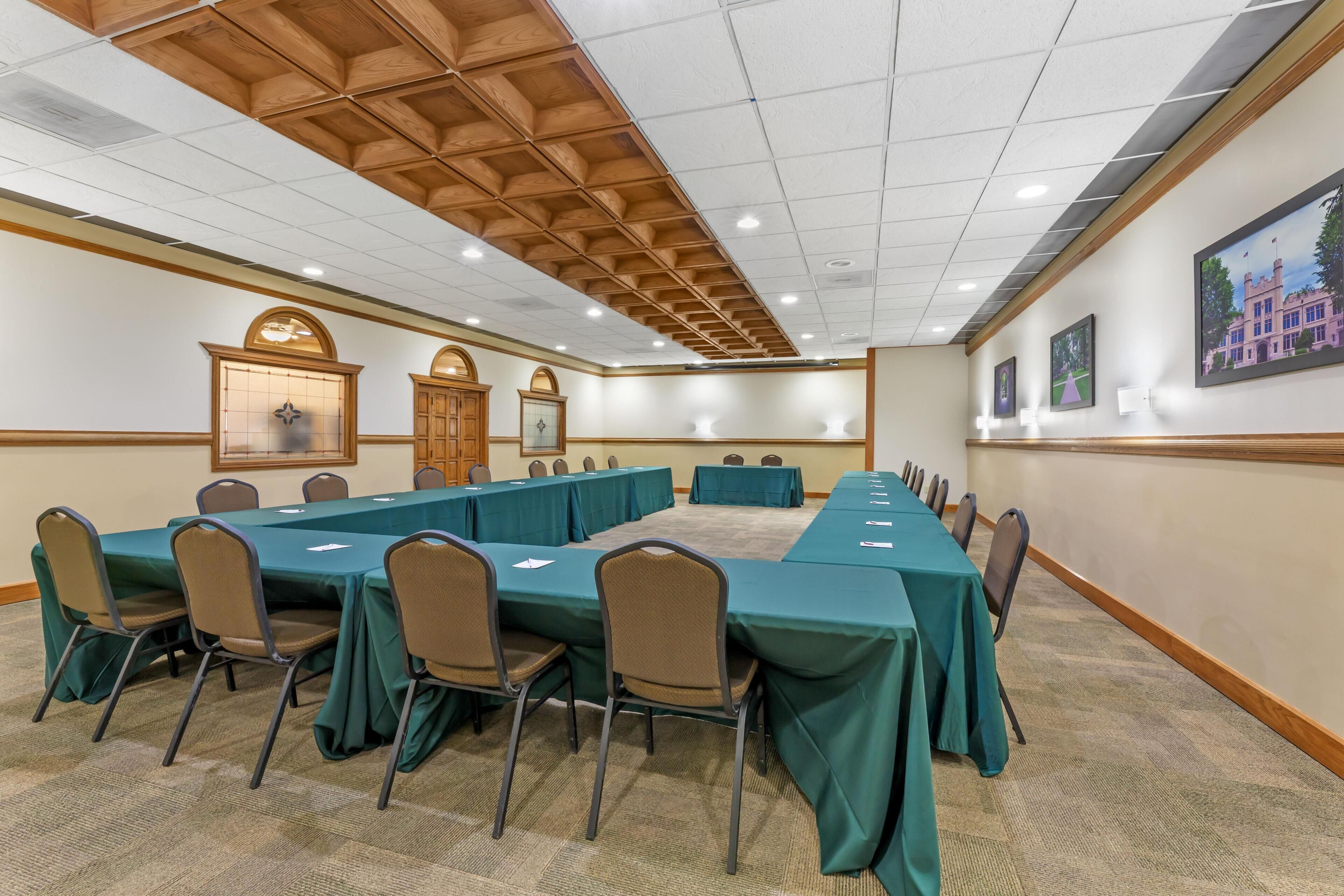 A conference room with a long table, chairs, and a wooden ceiling.
