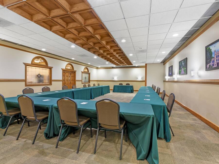 Uma sala de conferências com uma mesa comprida, cadeiras e teto de madeira.