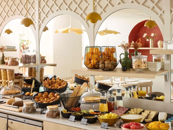 A buffet with various food items and a decorative archway. - Mercure Nice Marche aux Fleurs (Nice)
