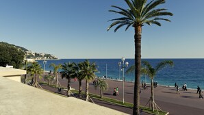 A coastal promenade with palm trees, a clear sky, and the sea in the background. - Mercure Nice Marche aux Fleurs (Nice)