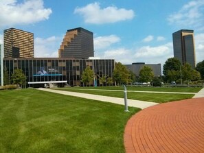 A modern building with a glass facade, surrounded by a well-maintained grassy area and a brick pathway. - Holiday Inn Express Detroit-Birmingham by IHG (Birmingham)