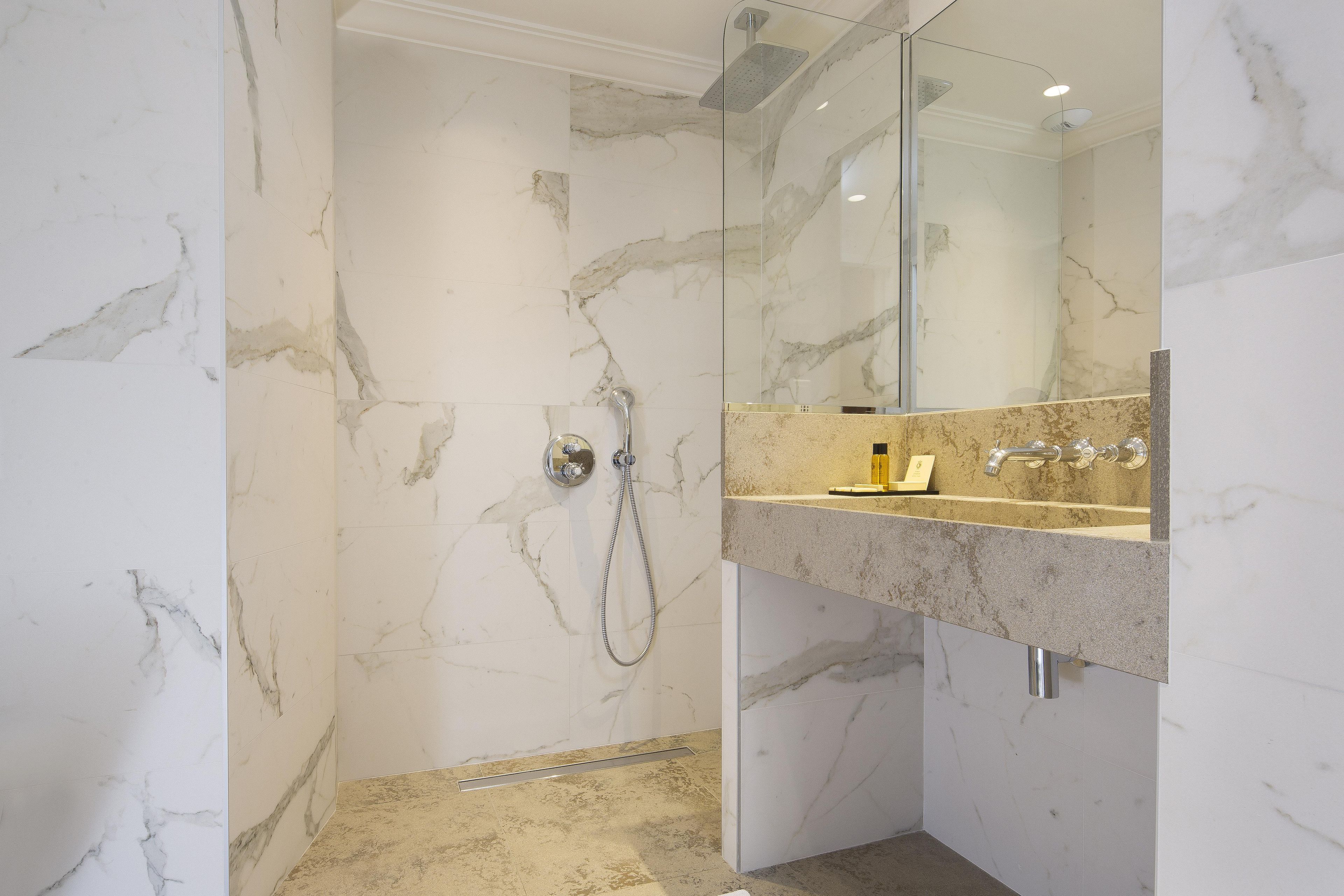 A bathroom with a shower, a sink, and a mirror.