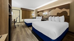 A hotel room with two beds, a desk, a chair, and a wardrobe.