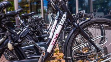 Varias bicicletas en fila, con nombres de marca y números de serie visibles, lo que indica un sistema de bicicletas compartidas.