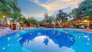 Una piscina al aire libre, sombrillas, sillones reclinables de piscina