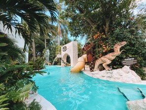 Una piscina al aire libre, sombrillas, sillones reclinables de piscina