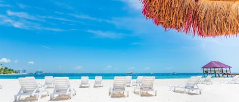 Plage, sable blanc, parasols, serviettes de plage