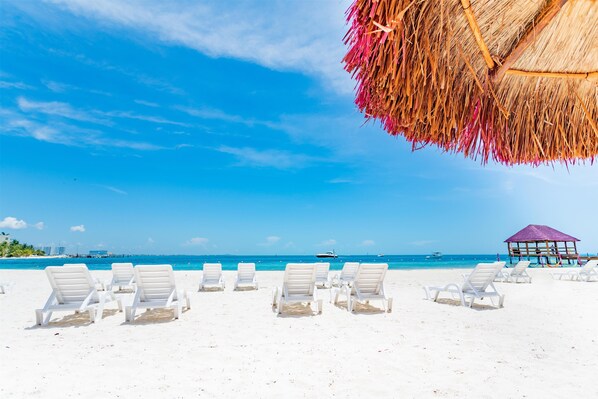 On the beach, white sand, beach umbrellas, beach towels