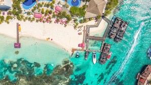 An aerial view of a coastal resort with a beach, a pier, and a swimming pool. - Oasis Palm - All Inclusive (Cancun)