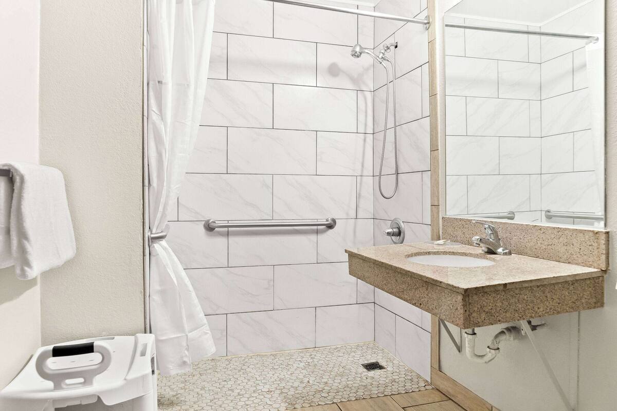 A modern bathroom with a shower, toilet, and sink.