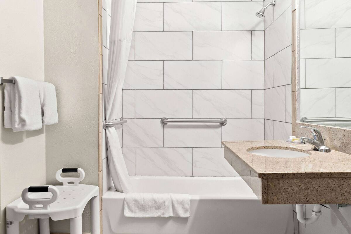 A bathroom with a bathtub, a sink, and a shower.