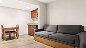 Ein modernes Wohnzimmer mit einer Couch, einem Holzesstisch und Stühlen.